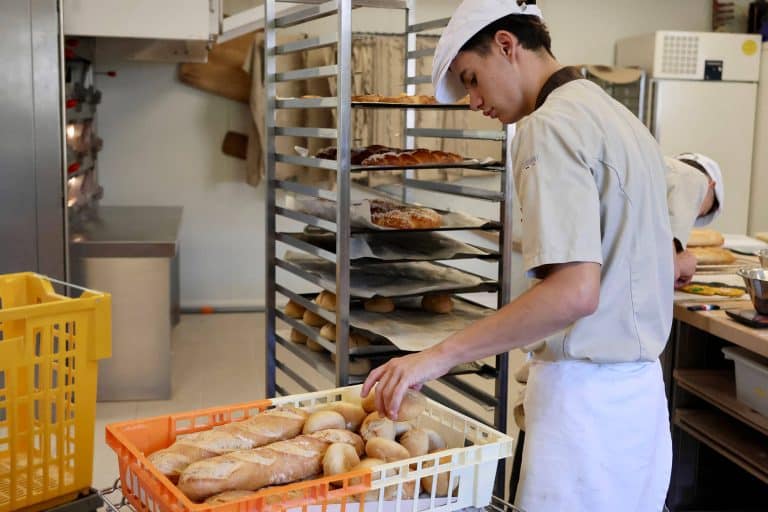 Élève en formation boulangerie manipulant des pains frais dans le laboratoire du lycée Saint-Joseph L’Amandier