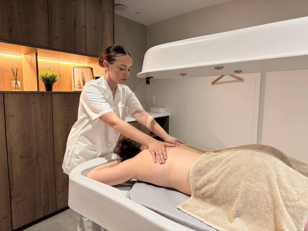 Étudiante en BTS Métiers de l’Esthétique, de la Cosmétique et de la Parfumerie réalisant un soin du corps en spa pédagogique au lycée L’Amandier