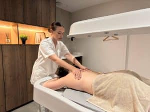 Étudiante en BTS Métiers de l’Esthétique, de la Cosmétique et de la Parfumerie réalisant un soin du corps en spa pédagogique au lycée L’Amandier