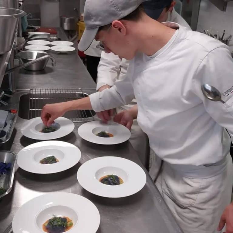 Élève de Bac Pro CSR dressant une entrée gastronomique en cuisine pédagogique