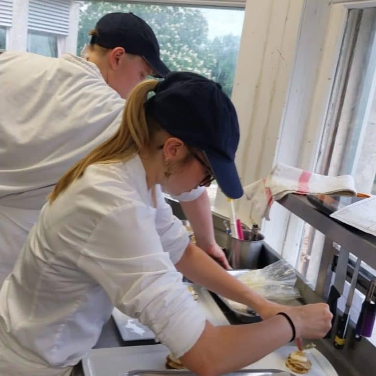 Élèves de Bac Pro CSR réalisant le dressage des desserts pendant la soirée gastronomique Bretagne Normandie